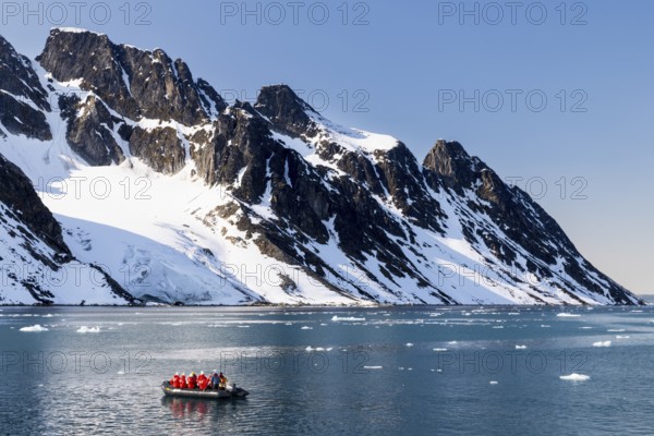 Zodiac in front of mountains with snow, sea, Smeerenburg, Spitsbergen, Svalbard