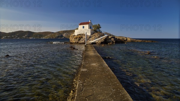 White chapel with red roof on a small island, connected to the mainland by a footbridge, chapel,