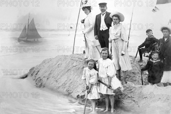 Family on the beach, 1910s, Victorian beach shot of a family with children next to a sailing boat