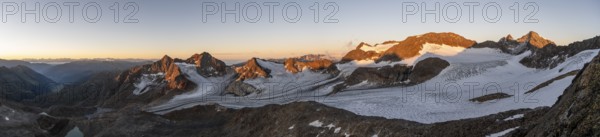 Picturesque high mountain landscape at sunrise with alpenglow, glacier and rocky mountain peaks in