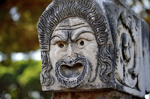 Ancient stone sculpture, stone carving of a mask, Roman theatre, ancient port city of Rome,