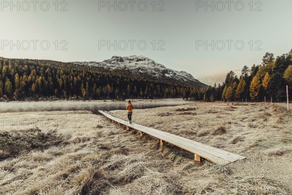 Young woman at Lake Staz near Sankt Moritz in the Engadine in Switzerland. Morning atmosphere with