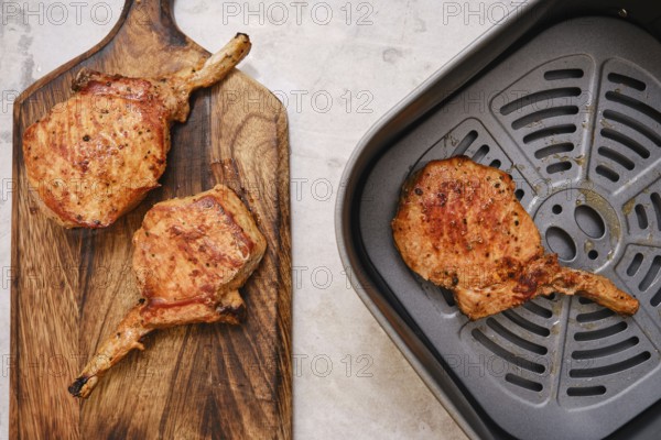 Juicy pork rib roasts are beautifully cooked to perfection, resting on a wooden cutting board. An