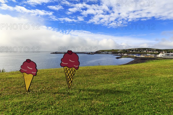 Two ice-cream cones in summer, signs in a meadow by the sea, fun decoration on Candy Day, Cumulus,