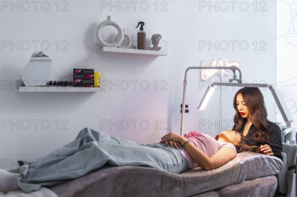 Beautician carefully examining a customer's face, preparing for a cosmetic treatment in a modern