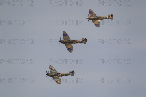 Supermarine Spitfire three warbird military aircraft in Royal air force RAF colours flying,