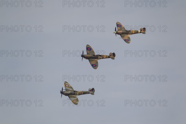 Supermarine Spitfire three warbird military aircraft in Royal air force RAF colours flying,