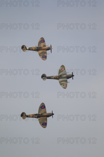 Supermarine Spitfire three warbird military aircraft in Royal air force RAF colours flying,