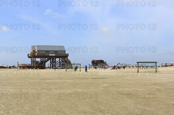 Pile dwellings, toilet block on the beach, beach chairs, football goal on the horizon, Sankt
