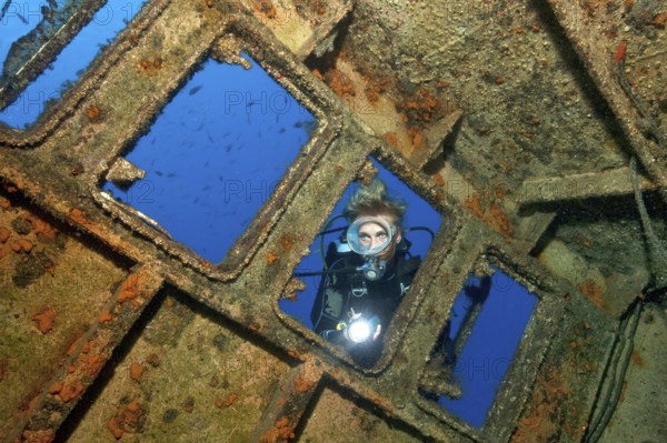 Diver looking from outside into wreck ship El Peñon, East Atlantic, Tabaita, Tenerife, Canary