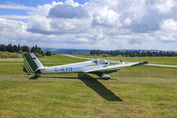 Motor glider of the type Scheibe SF.25C Falke standing on Wasserkuppe airfield, in the background