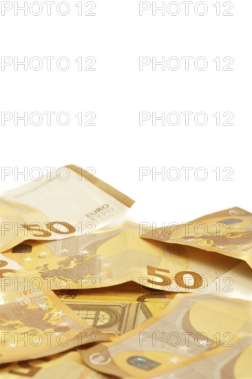 Scattered fifty euro banknotes forming a corner frame on a white background, ideal for finance and