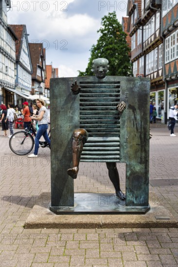 Bronze sculpture, A man pushes through the gate, French artist Joan Ipoustéguy, pedestrian