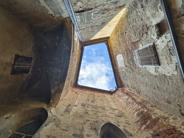 View through an open roof of blue sky with clouds surrounded by old stone walls Riegersburgs Styria