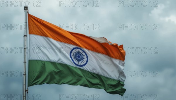 The Indian flag waves proudly against a cloudy sky, symbolizing the nation's independence and
