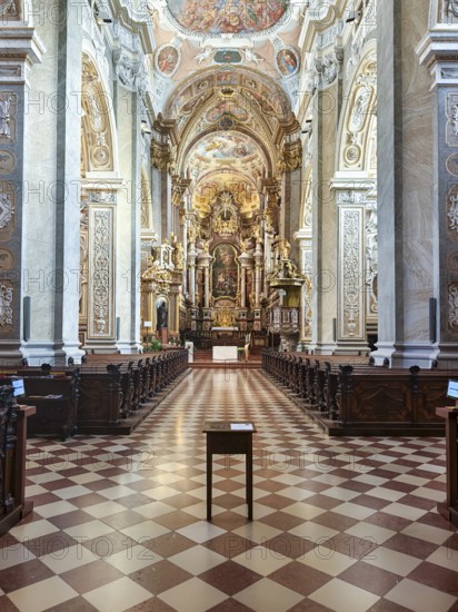 Opulently furnished nave with ornate Baroque ceiling decorations and symmetrical structure,