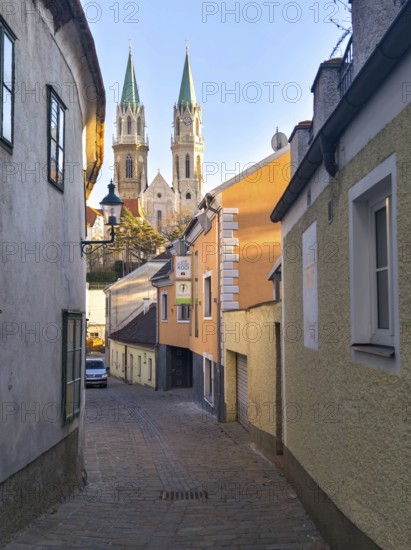 Narrow old town path with a view of high church towers in the warm light of late day,