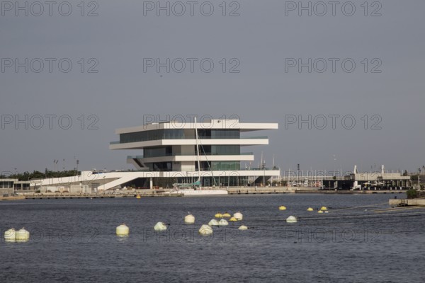 Modern building with clean lines on the water, surrounded by buoys
