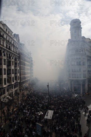Dense crowds through a foggy city street MascletÃ¡ de Fallas