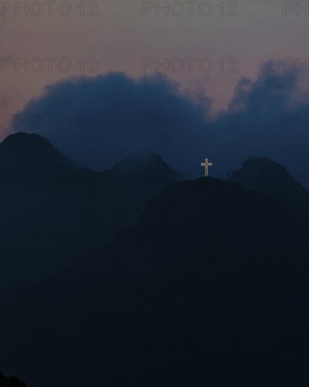 Illuminated steel cross on Monte Mar di Capanna, night shot, above Porto Azzurro, Elba Island,