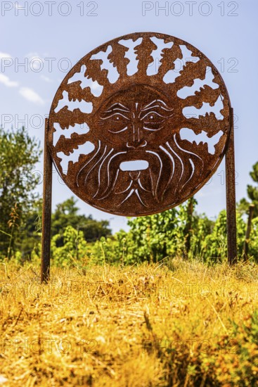 Rusty plaque with motif of the god of wine Bacchus, near the Arrighi winery, Porto Azzurro, Elba