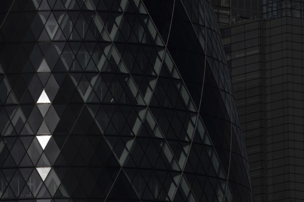 The Gherkin skyscraper building close up of window details with sunlight illuminating three