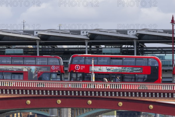 Two red double decker buses driving over a bridge, City of London, England, United Kingdom