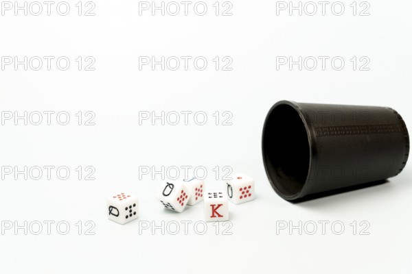 White poker dice with red and black markings rolling out of dark brown dice cup on white background