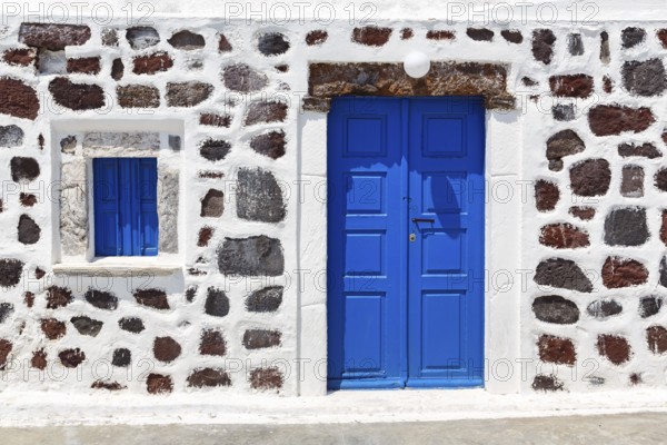 Bright blue door and blue shutter in stone wall, Chapel of Agios Nikolaos Mavrorachidi, Akrotiri,