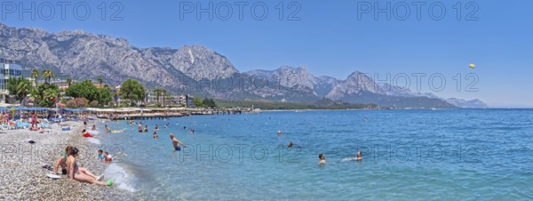 KEMER, TURKEY - JULY 5, 2025 Kemer municipality public beach with vibrant pebble under a clear,