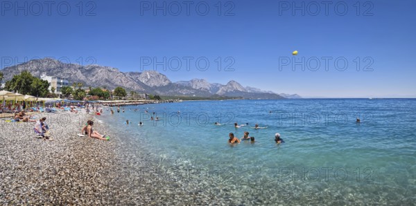 KEMER, TURKEY - JULY 5, 2025 Kemer municipality public beach with vibrant pebble under a clear,