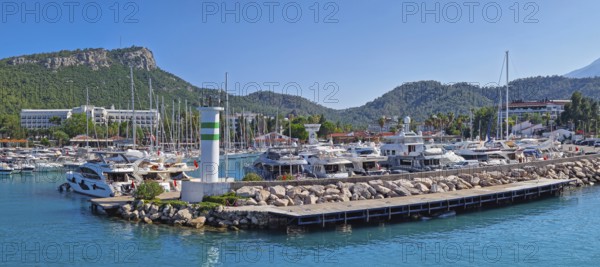 KEMER, TURKEY - JULY 3, 2025 Marina panoramic view with Calis Hill in the background. Rocky pier