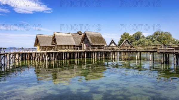 Historic pile dwellings on the shore of a lake with reflecting water, pile dwellings Unteruhldingen