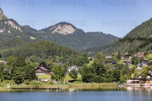 Idyllic landscape with houses by the lake, framed by wooded hills and mountains, Altaussee, Styria,