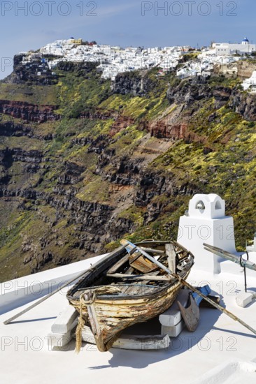 Rowing boat, wreck, decoration on a house roof, steep coast, edge of the caldera, Firostefani,
