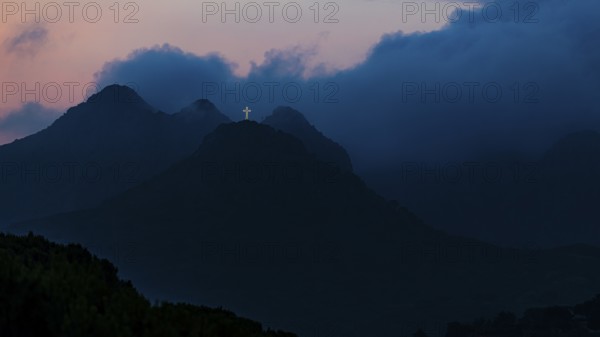 Illuminated steel cross on the summit of Monte Mar di Capanna, above Porto Azzurro, night shot,