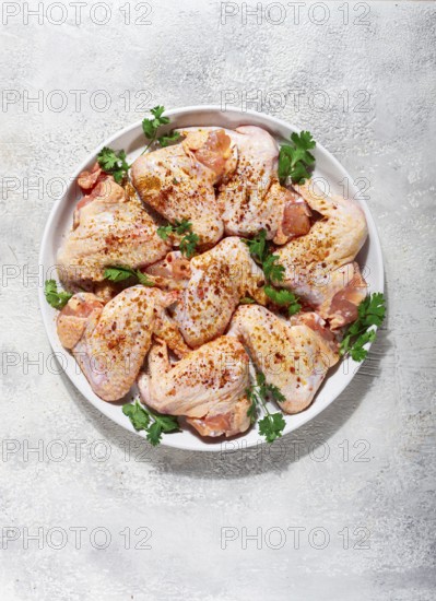 Marinated chicken wings prepared for grilling with spices and fresh herbs ready for cooking