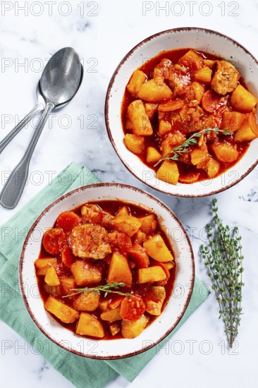 Meat goulash with potatoes and carrots, sweet peppers, in a saucepan, top view, traditional