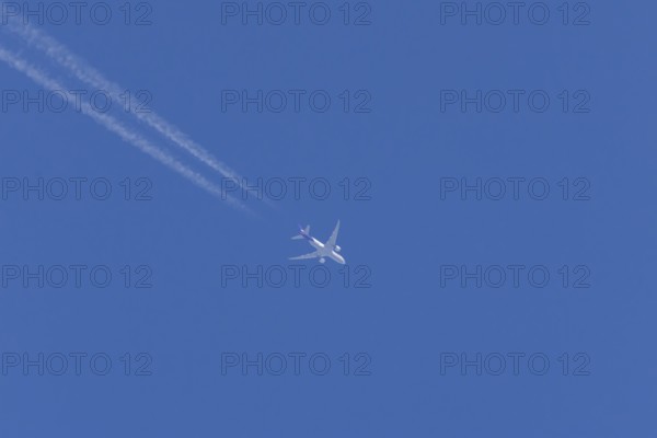 Airbus A300-600RF jet aircraft of FedEx Express airlines in flight in a blue sky with vapour trails