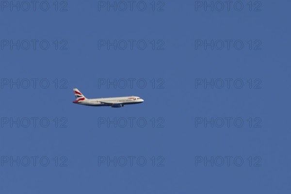 Airbus A320-232 jet passenger aircraft of British Airways airlines in flight in a blue sky, London,