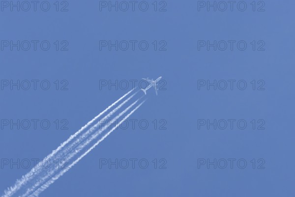 Airbus A340-300 jet aircraft of Lufthansa airlines in flight in a blue sky with vapour trails or
