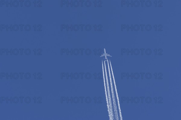 Airbus A340-300 jet aircraft of Lufthansa airlines in flight in a blue sky with vapour trails or