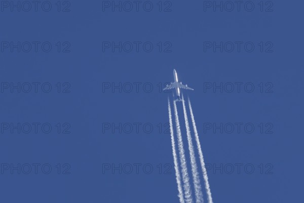 Airbus A340-300 jet aircraft of Lufthansa airlines in flight in a blue sky with vapour trails or