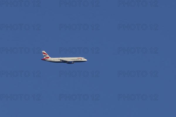 Airbus A320-232 jet passenger aircraft of British Airways airlines in flight in a blue sky, London,