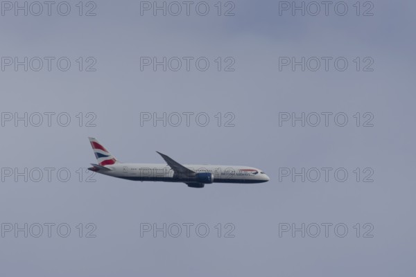 Boeing 787-9 Dreamliner jet passenger aircraft of British Airways airlines in flight in a blue sky,