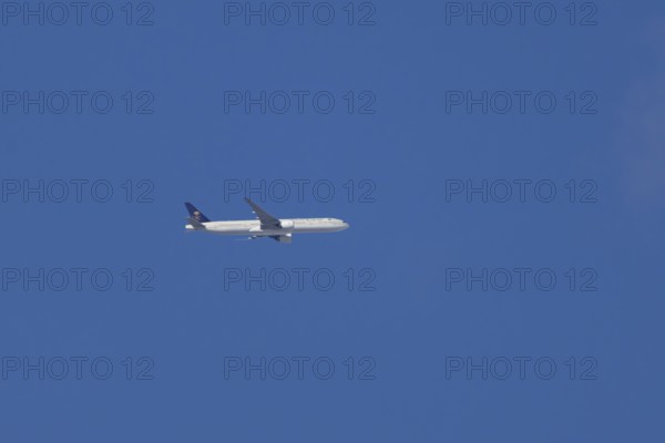 Boeing 777 jet passenger aircraft of Saudi airlines in flight in a blue sky, England, United