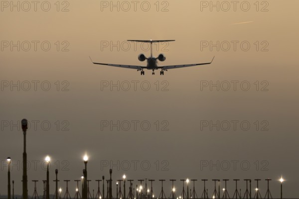 Bombardier Global business jet passenger aircraft in flight landing at sunset at London Stansted