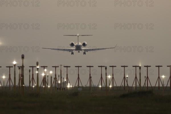 Bombardier Global business jet passenger aircraft in flight landing at sunset at London Stansted