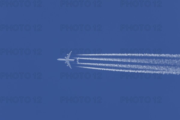 Airbus A340-300 jet aircraft of Lufthansa airlines in flight in a blue sky with vapour trails or