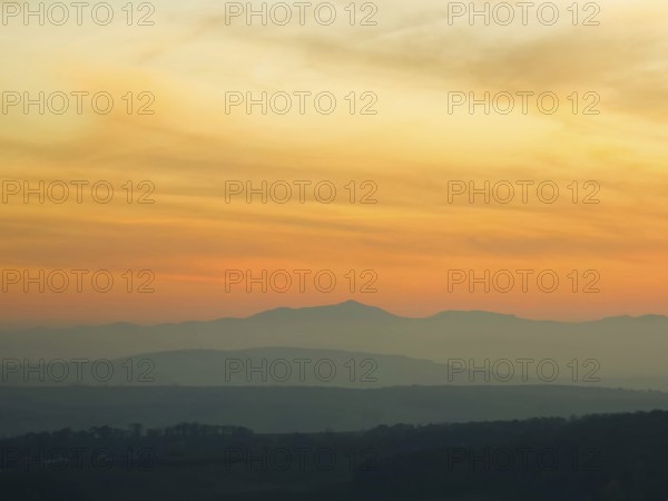Silhouettes of mountains in the soft light of a pastel-coloured sunset Leiserbergen Weinviertel